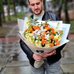 Букет из оранжевых кустовых роз, орхидей и маттиолы